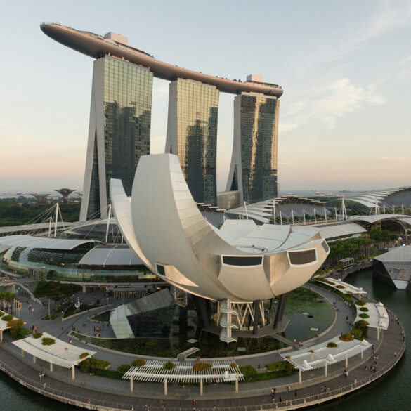 Aerial view of Marina Bay Sands and the ArtScience Museum framed against the Singapore skyline at sunset.