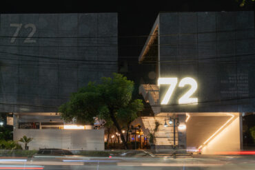Night view of the modern concrete façade and illuminated “72” signage of 72 Courtyard Bangkok, a lifestyle and nightlife destination in Thonglor Thailand.