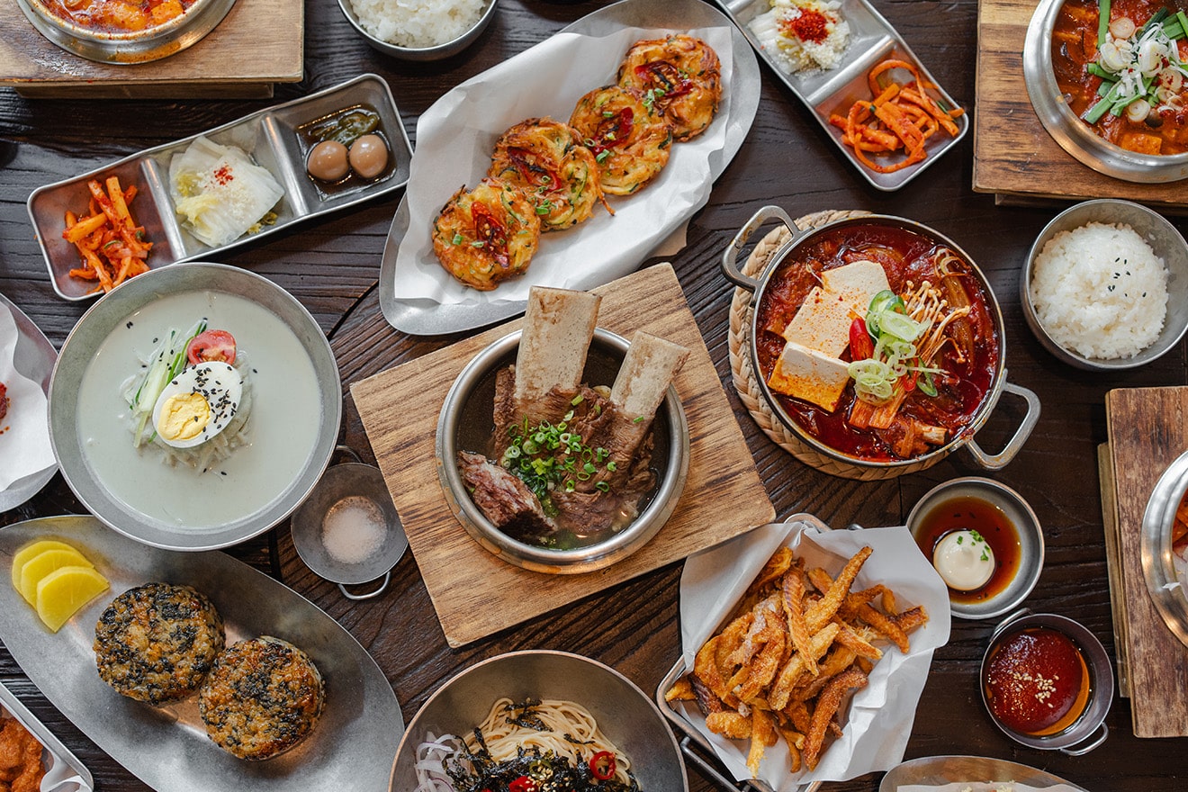 Assorted Korean BBQ dishes including braised ribs, kimchi pancakes, and cold noodles at Gochu Singapore, a new oakwood-fired Korean restaurant
