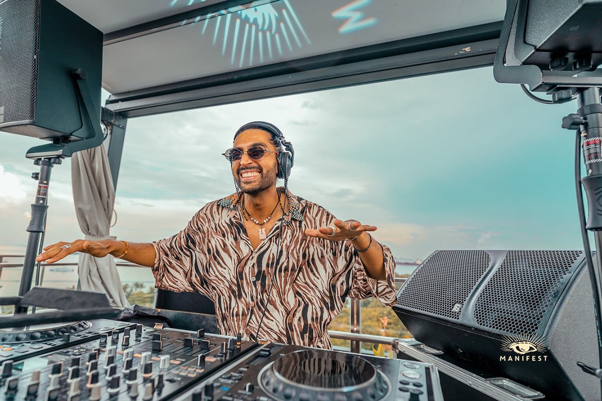 DJ HIMMAT playing a rooftop sunset set for Manifest Singapore, blending deep house, Afro beats, and organic electronica with panoramic city views.
