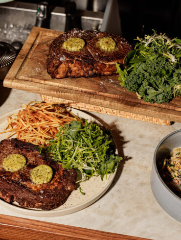 Grilled ribeye steak with smoked Kampot pepper butter, wild porcini ravioles, and crispy string potatoes at Merci Marcel, Robertson Quay, Singapore.
