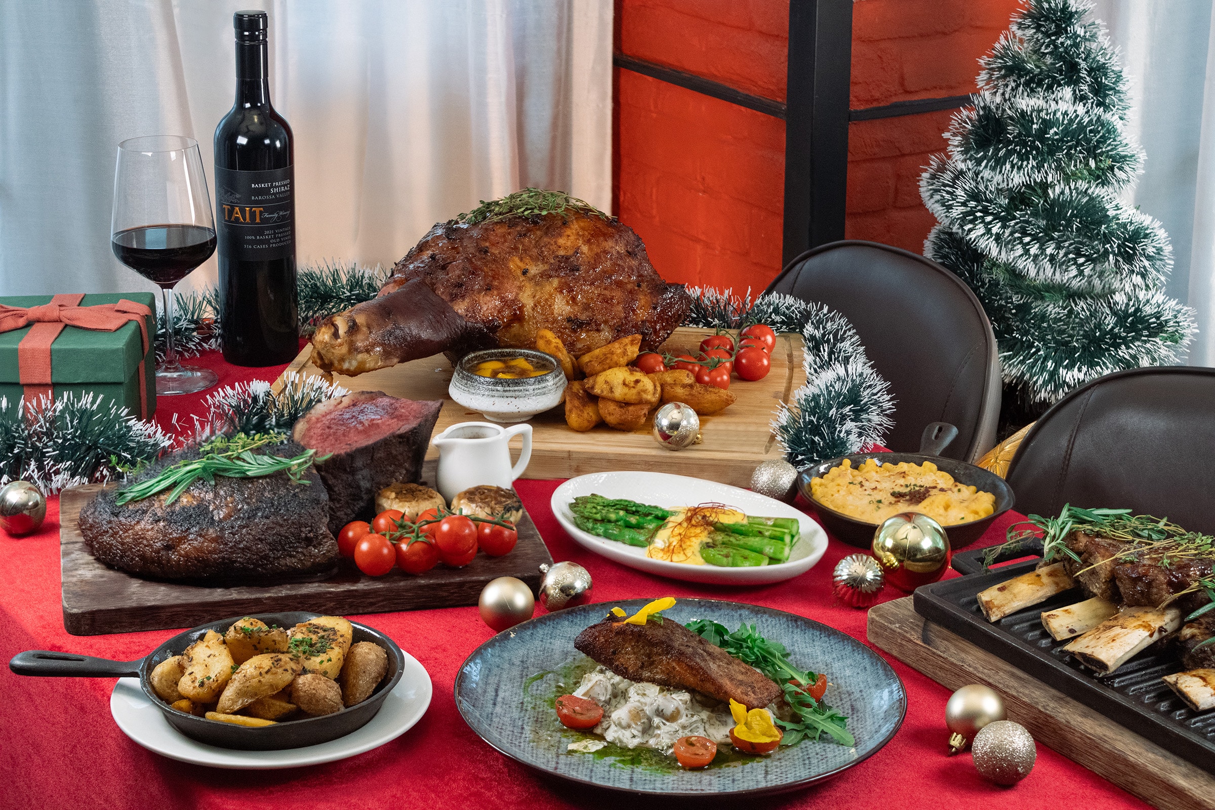 Barossa Steak & Grill's Christmas 2025 takeaway spread featuring roasted lamb leg, prime rib, mac and cheese, grilled vegetables, and festive décor — ideal for corporate Christmas dinners in Singapore.