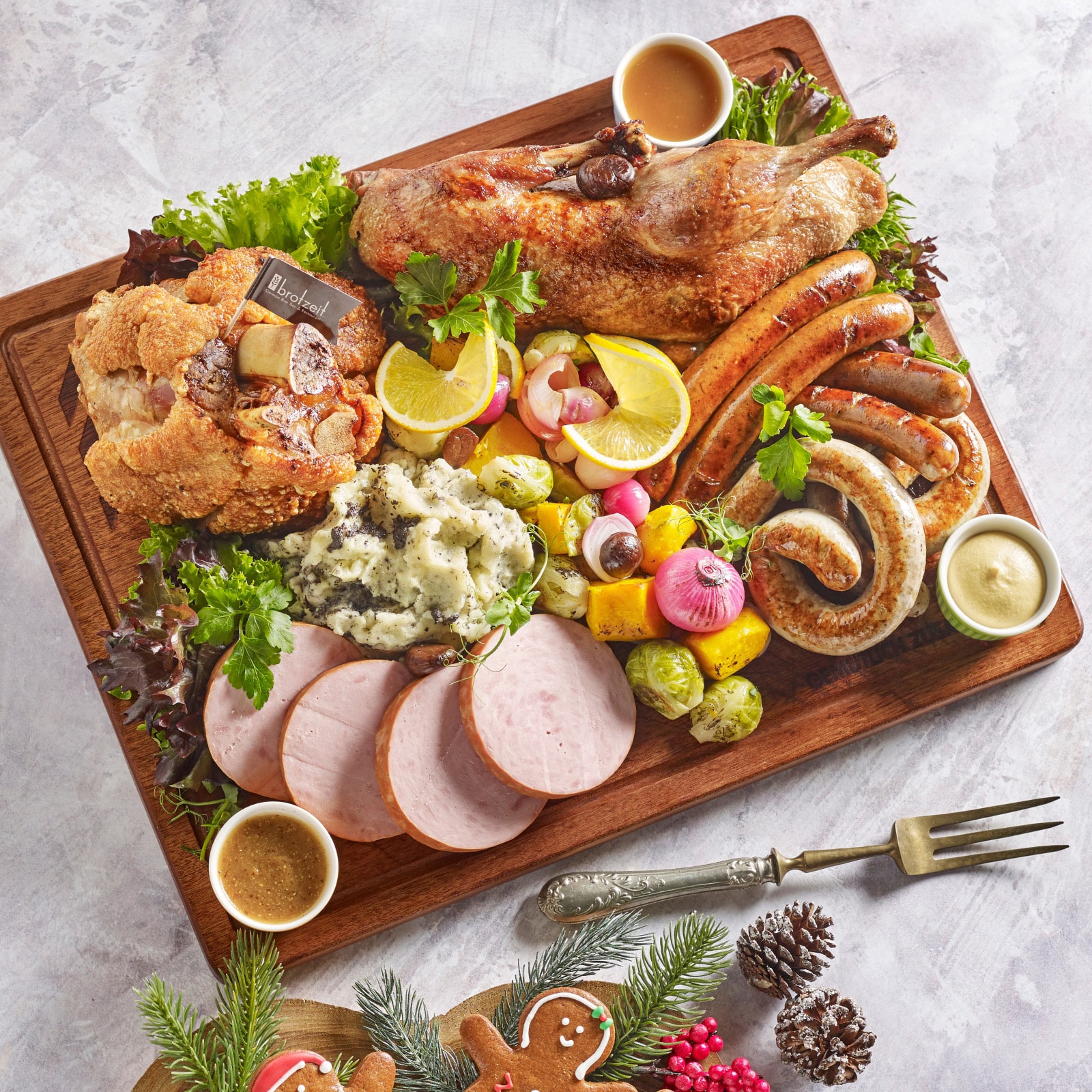 German Christmas meat platter from Brotzeit with crispy pork knuckle, roasted duck, sausages, ham, and truffle mashed potatoes, perfect for holiday takeaways in Singapore.