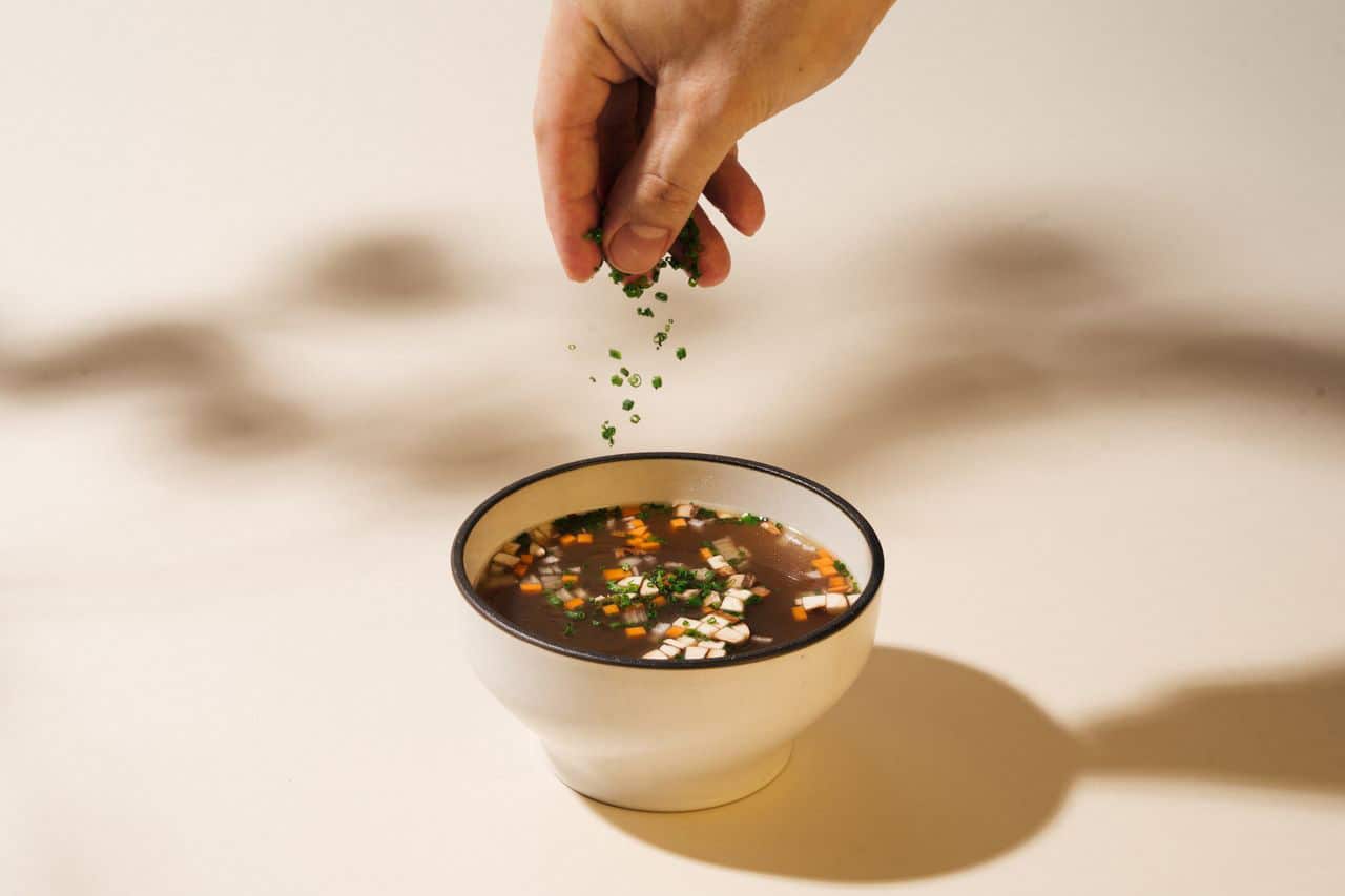 Close-up of beef bone broth with diced vegetables at Curly in Dempsey Hill, Singapore – part of the new wellness-focused dining and grocer concept.