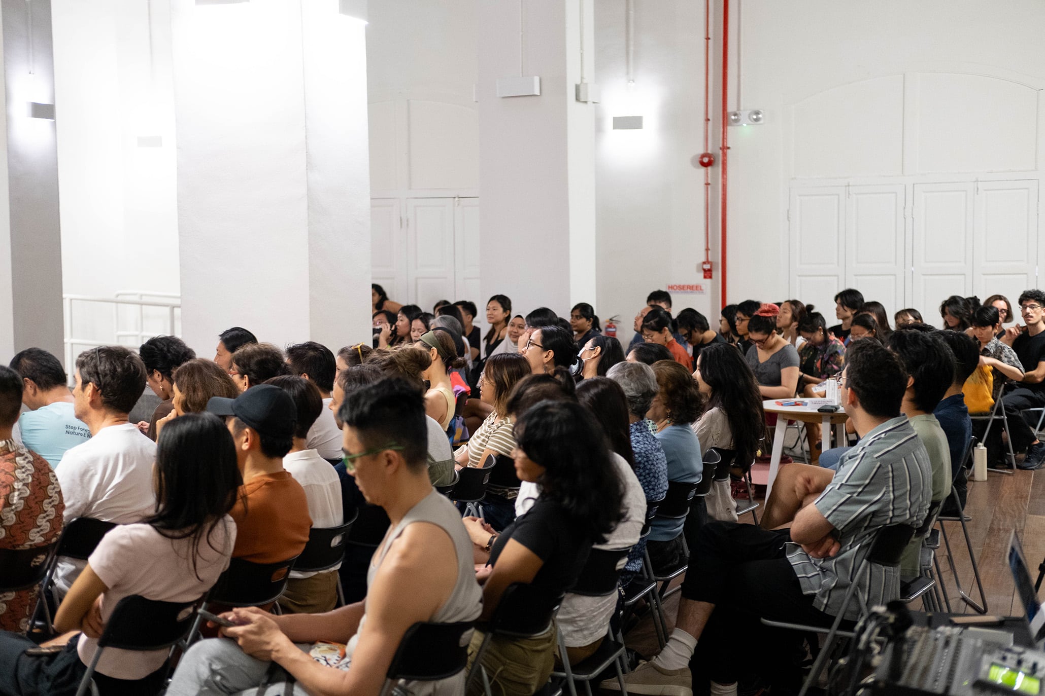 Audience seated at a climate and ecology talk during the Living Earth Festival in Singapore, showcasing engaged urban participants in a community-led discussion.