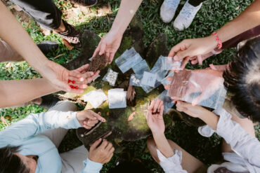Hands exchanging seeds and soil samples during a nature-based workshop at the Living Earth Festival in Singapore, fostering biodiversity and community learning.