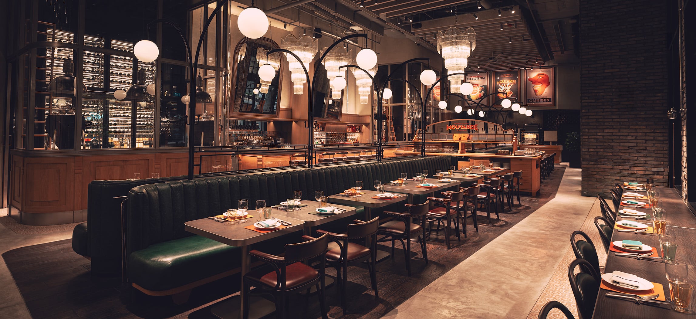 Elegant interior of Moutarde at Resorts World Sentosa Singapore – French woodfire bistro by Chef Paul Pairet with chandeliers and leather booth seating.