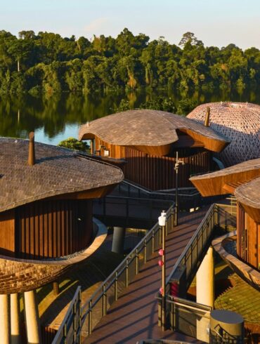 Scenic shot of the eco-conscious treehouse villas at Mandai Rainforest Resort by Banyan Tree, overlooking the Upper Seletar Reservoir in Singapore.