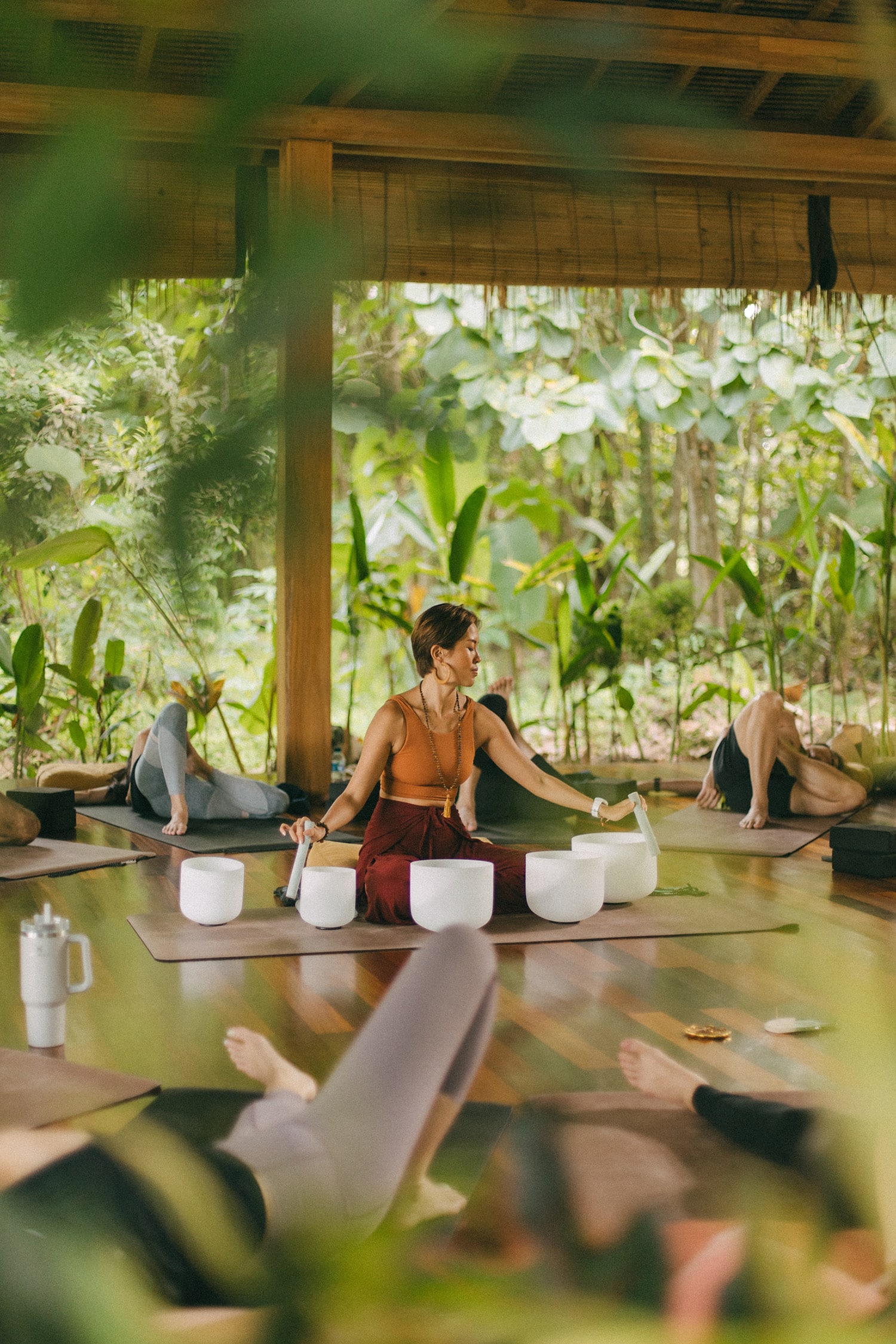 Woman leading a sound healing session in the rainforest at Mandai Rainforest Resort during the Rainforest Festival by Banyan Group in Singapore.
