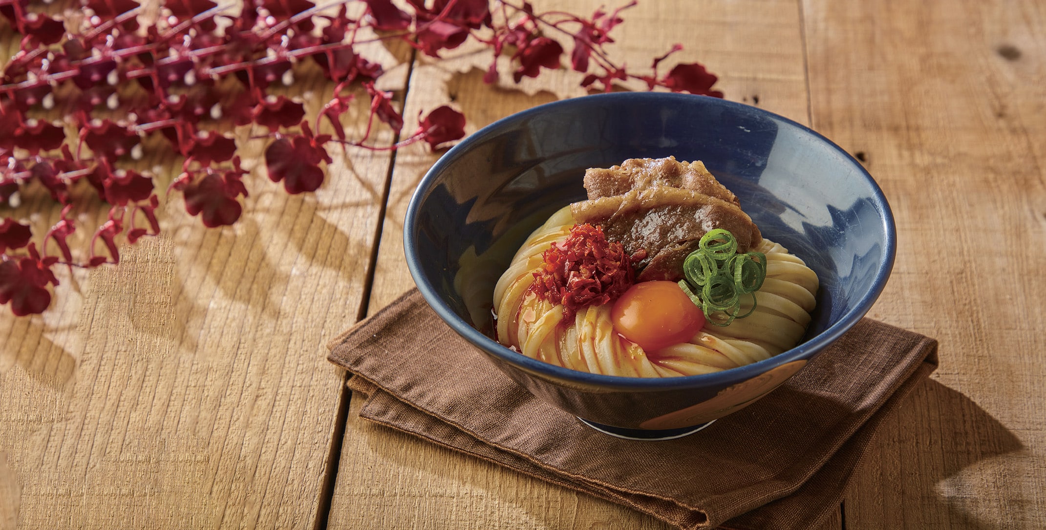 Bowl of handmade spicy beef shoyu udon at Udon Shin, Singapore — Tokyo-based noodle house known for fresh-cut udon and bold, comforting flavours.