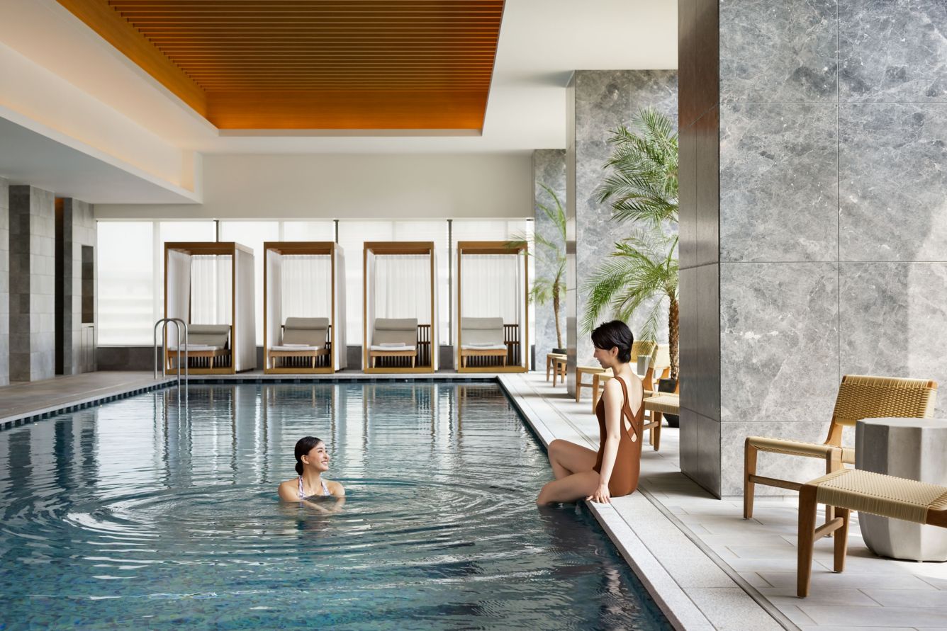 Indoor swimming pool at The Westin Yokohama, with private cabanas, tropical palms, and spa-like ambiance—ideal for wellness-focused stays in Japan.