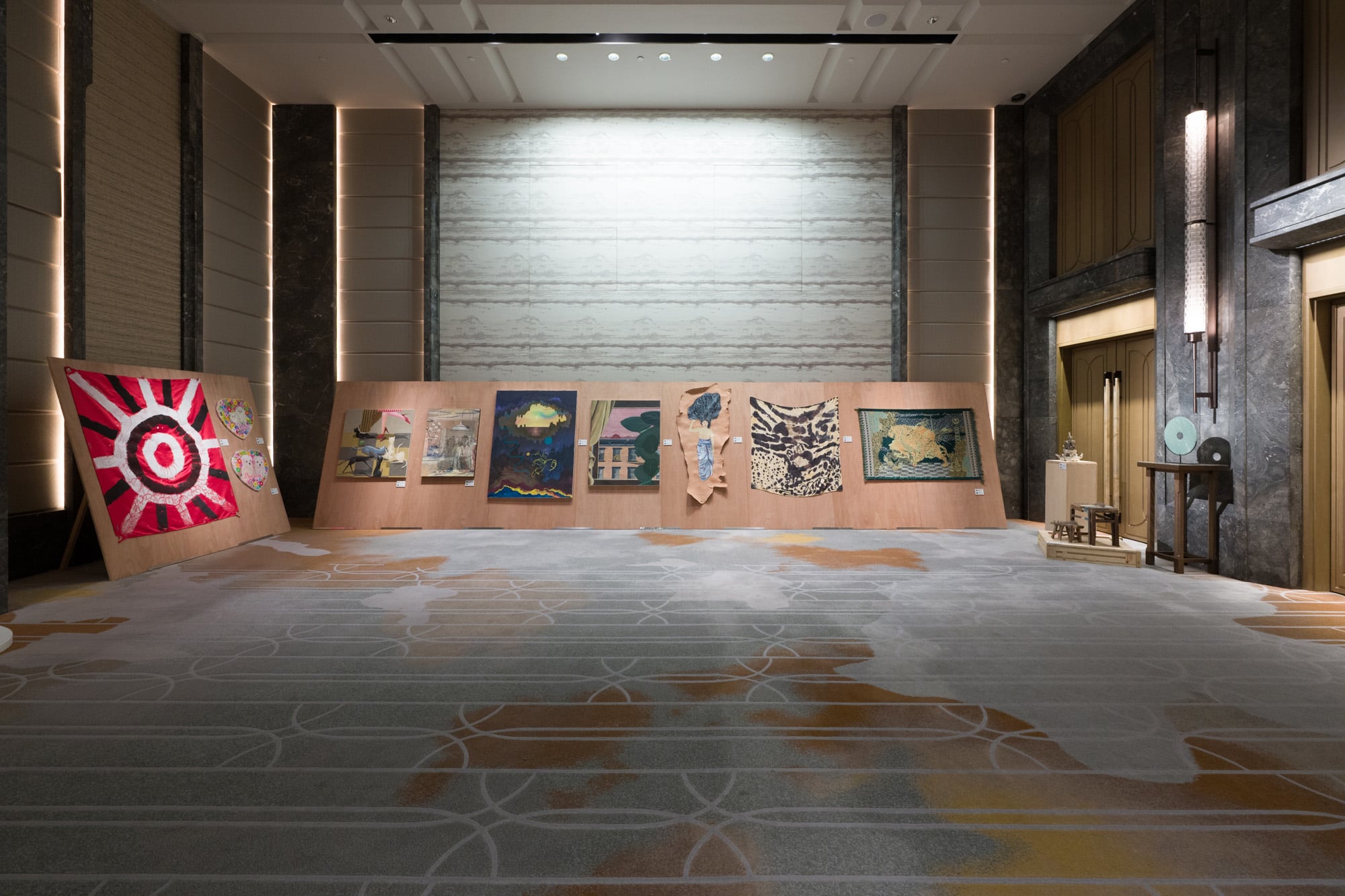 Installation view of artworks at Para Site 2025 Benefit Auction in Hong Kong, featuring contemporary textile and mixed media pieces displayed on wooden panels in a luxury hotel ballroom.