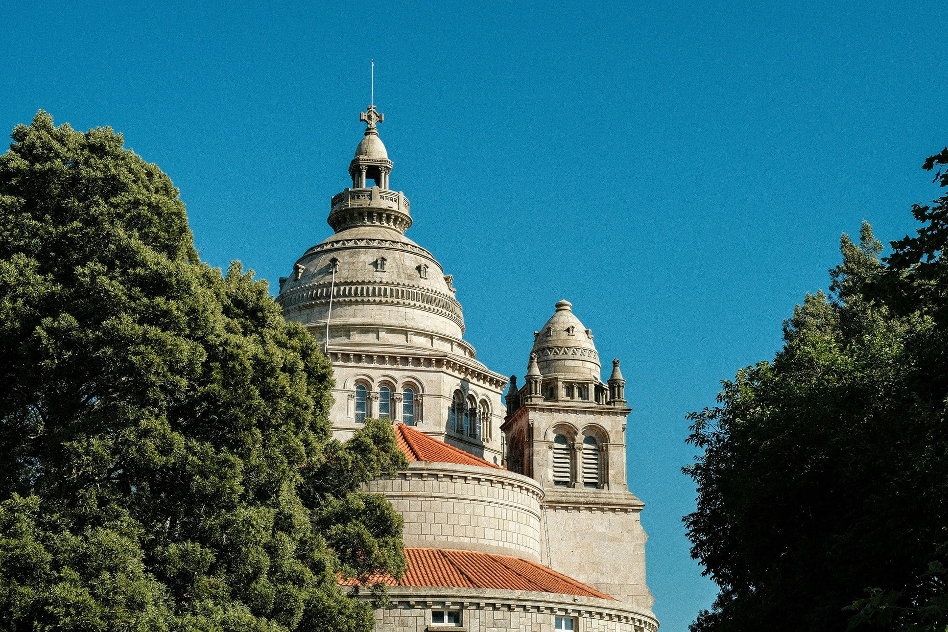 The iconic Sanctuary of Santa Luzia in Viana do Castelo, Portugal, framed by lush trees — a cultural highlight on northern Portugal driving routes.