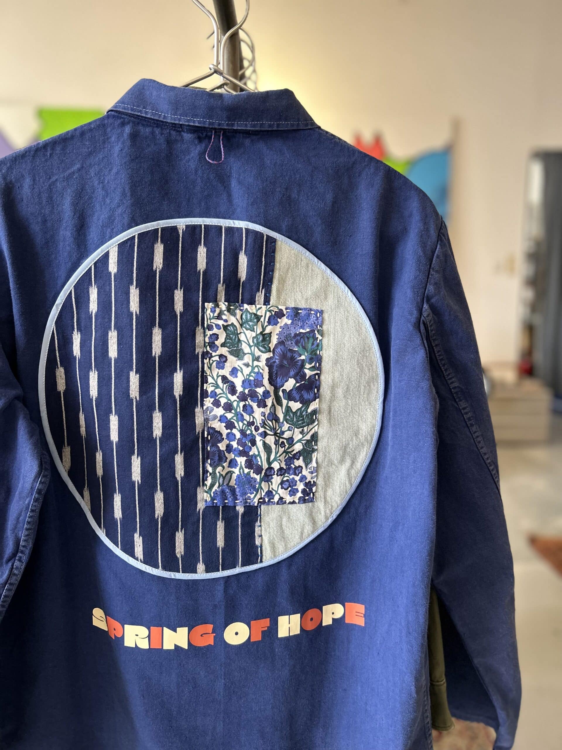Upcycled denim jacket by FIN Crafted Goods with circular patchwork, indigo fabrics, and floral textile details, showcasing repair-focused craftsmanship in Singapore
