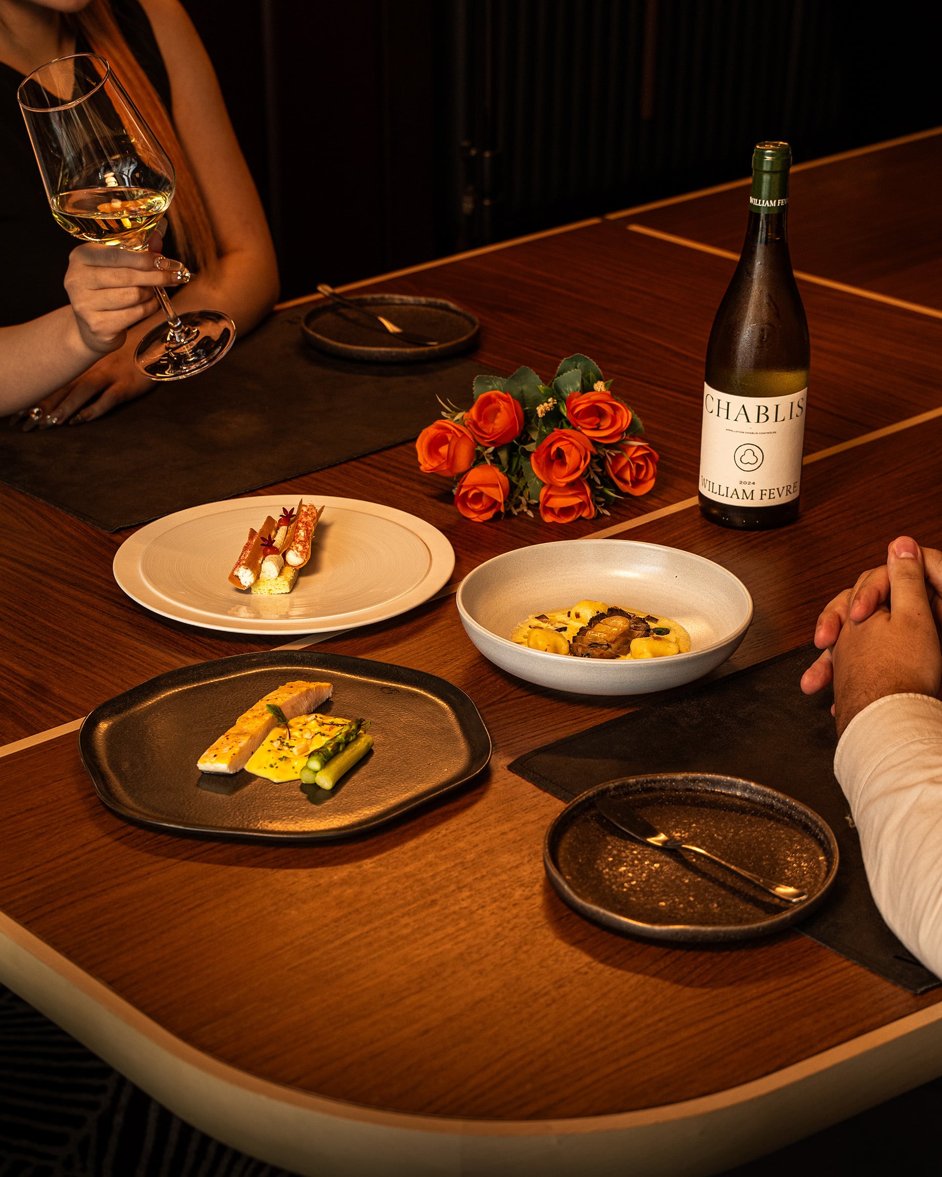Plated Valentine’s Day dinner at VUE Bar & Grill, featuring lobster, foie gras, and beef wagyu with a bottle of William Fèvre Chablis.