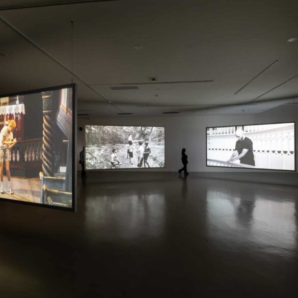 Multi-channel video installation by Young-jun Tak featuring suspended screens projecting both colour and black-and-white footage in a dimly lit gallery at Taipei Biennial 2025.