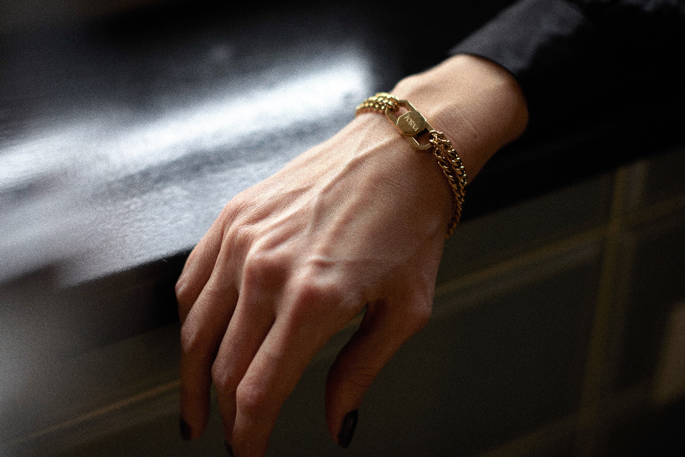 FORNA gold bracelet with engraved clasp detail, styled on the wrist to showcase discreet luxury intimacy jewellery made for everyday wear.