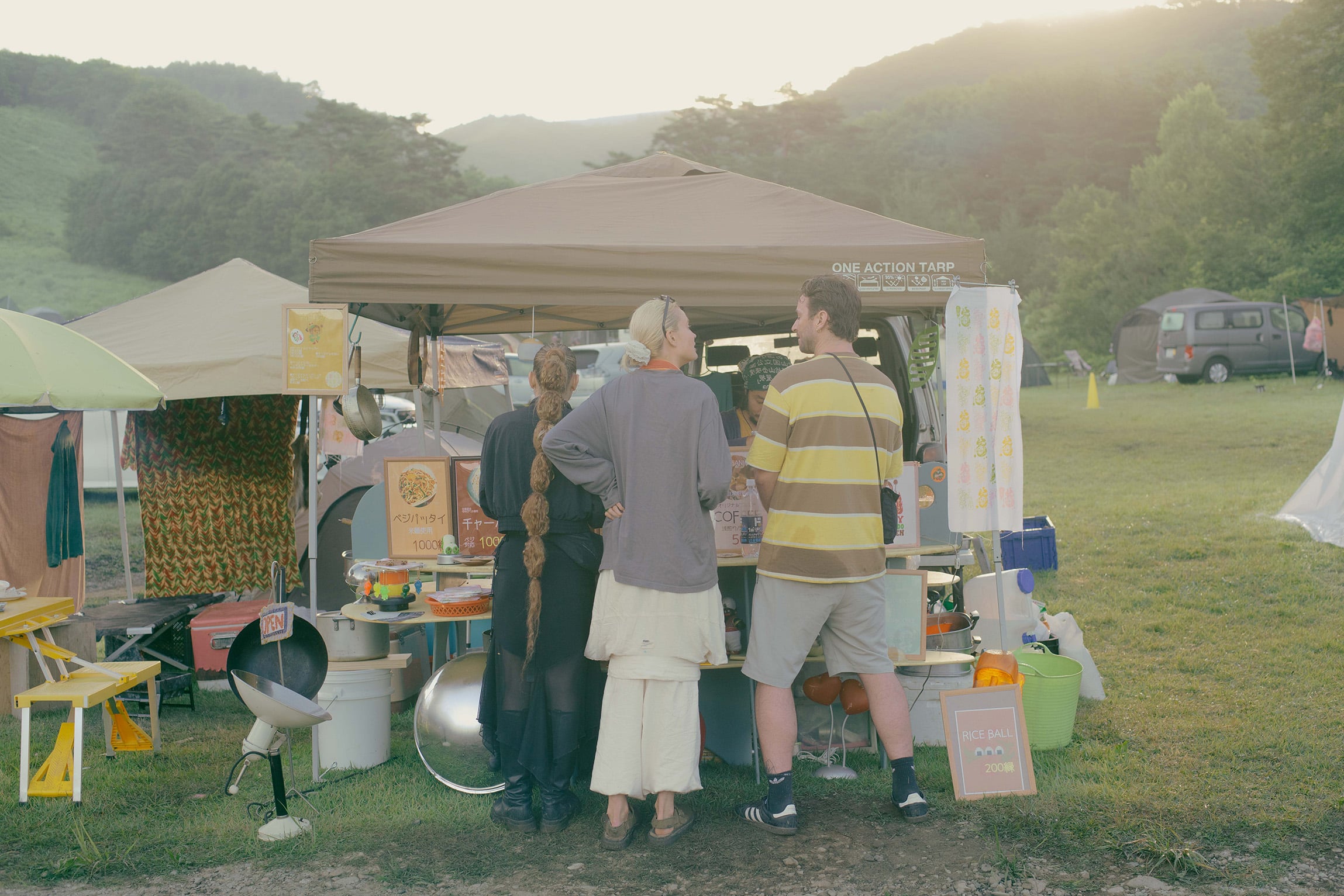 Food stall and festival attendees at rural 2025 campground, showcasing local Japanese vendors and slow living atmosphere at techno festival in Japan