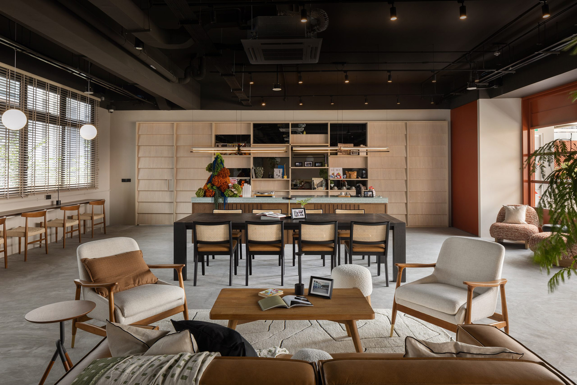 Interior of Alma House at New Bahru with lounge seating and communal tables in a calm, home-like space.