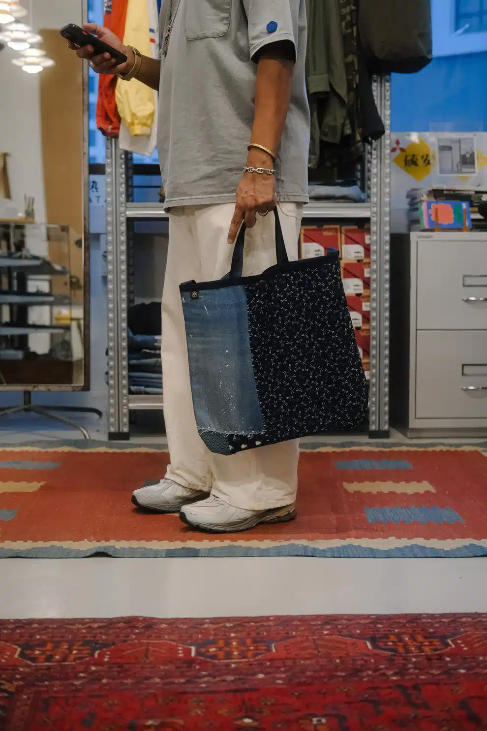 Person holding FIN Crafted Goods Tote Bag Boro Envelope made from indigo denim and patterned fabric, showcasing repair-focused craftsmanship in Singapore.