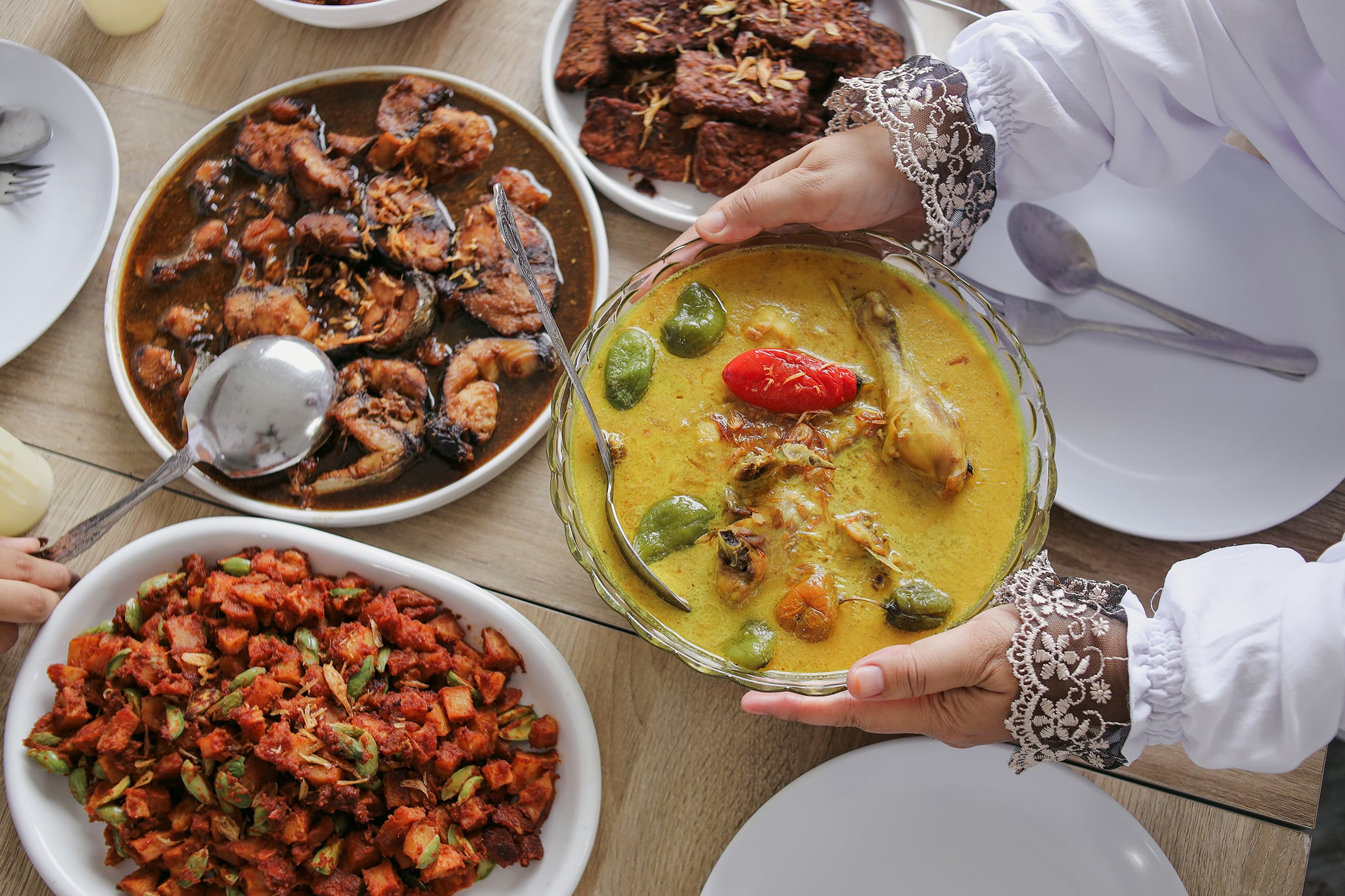 Traditional iftar spread with opor ayam, sambal dishes, and festive Ramadan meal setting.
