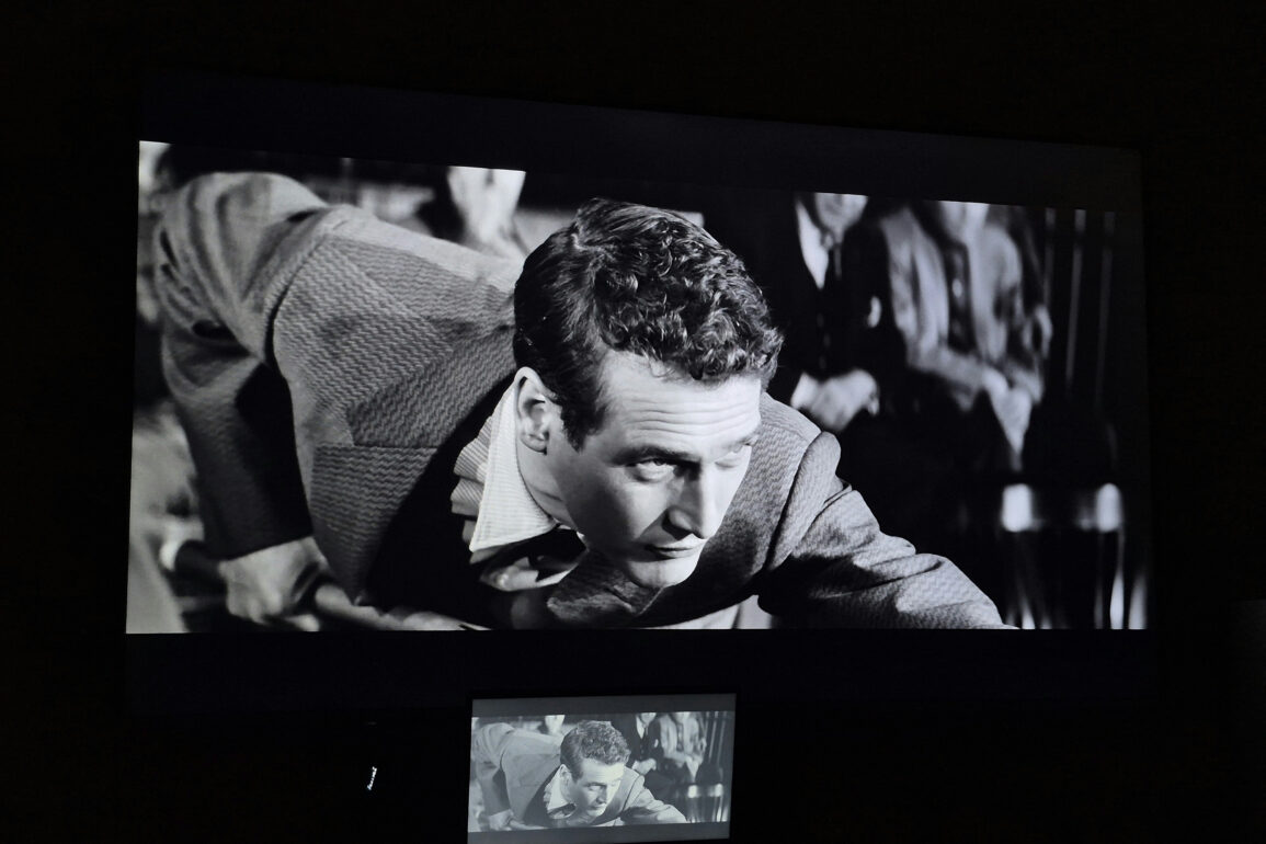 Black-and-white film projected on a large screen during a classic cinema screening featuring Paul Newman