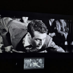 Black-and-white film projected on a large screen during a classic cinema screening featuring Paul Newman
