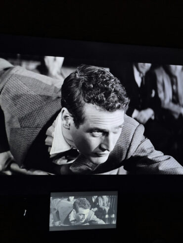 Black-and-white film projected on a large screen during a classic cinema screening featuring Paul Newman