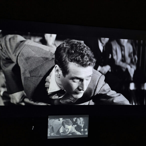 Black-and-white film projected on a large screen during a classic cinema screening featuring Paul Newman