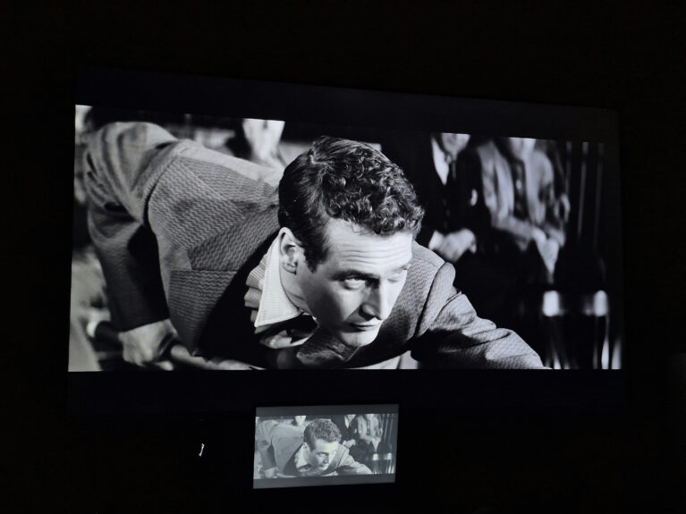 Black-and-white film projected on a large screen during a classic cinema screening featuring Paul Newman