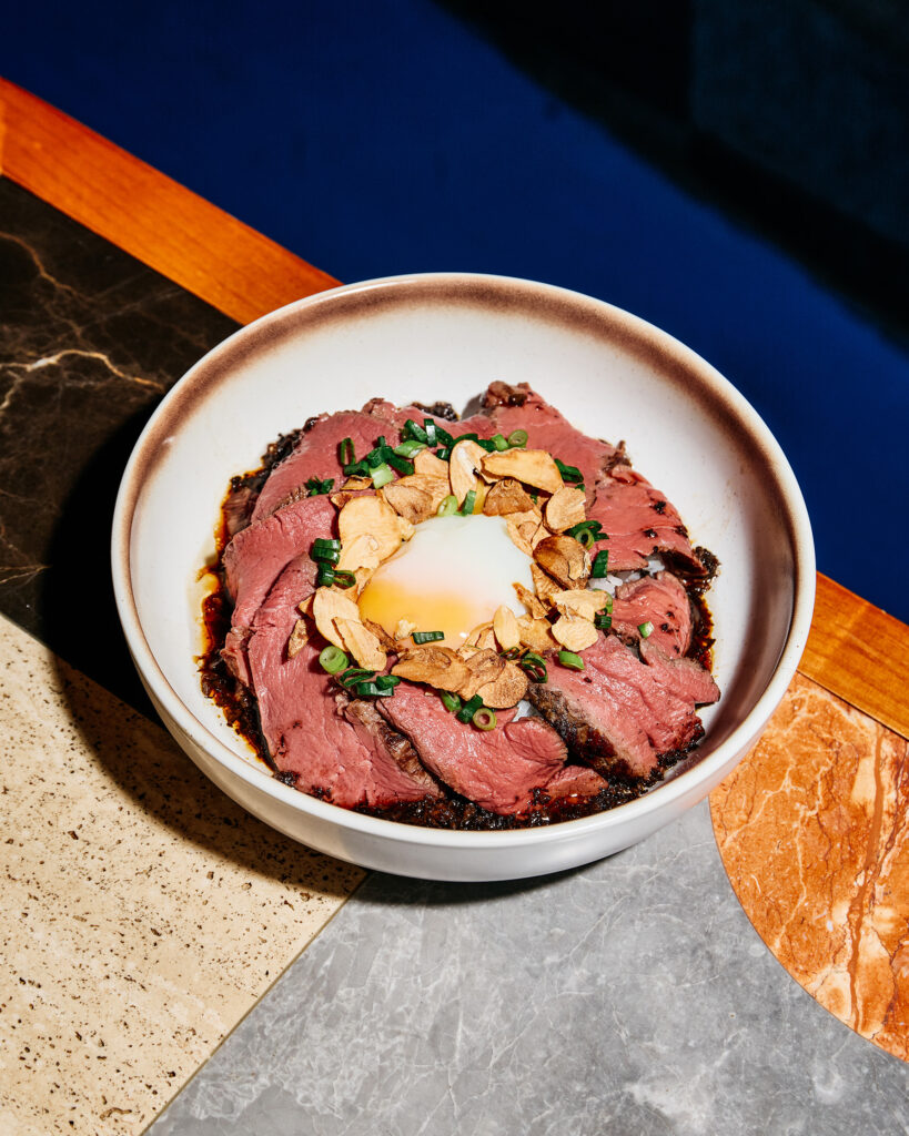 Beef tenderloin rice bowl with onsen egg, garlic chips, and truffle jus at Average Service Singapore