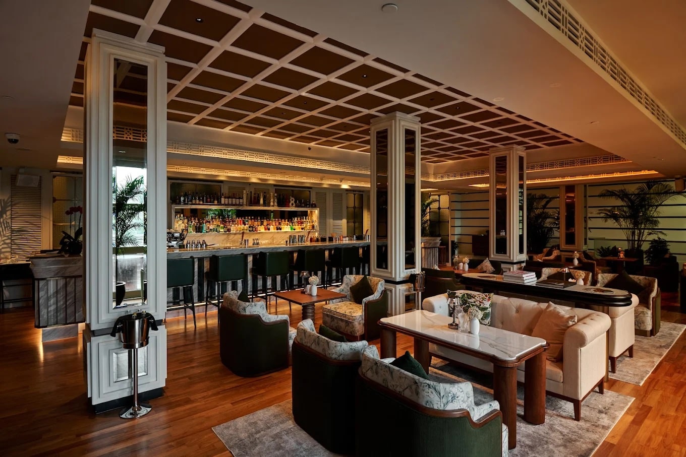 Madison House Singapore members lounge and bar with marble counter, warm lighting, and elegant seating at Fort Canning
