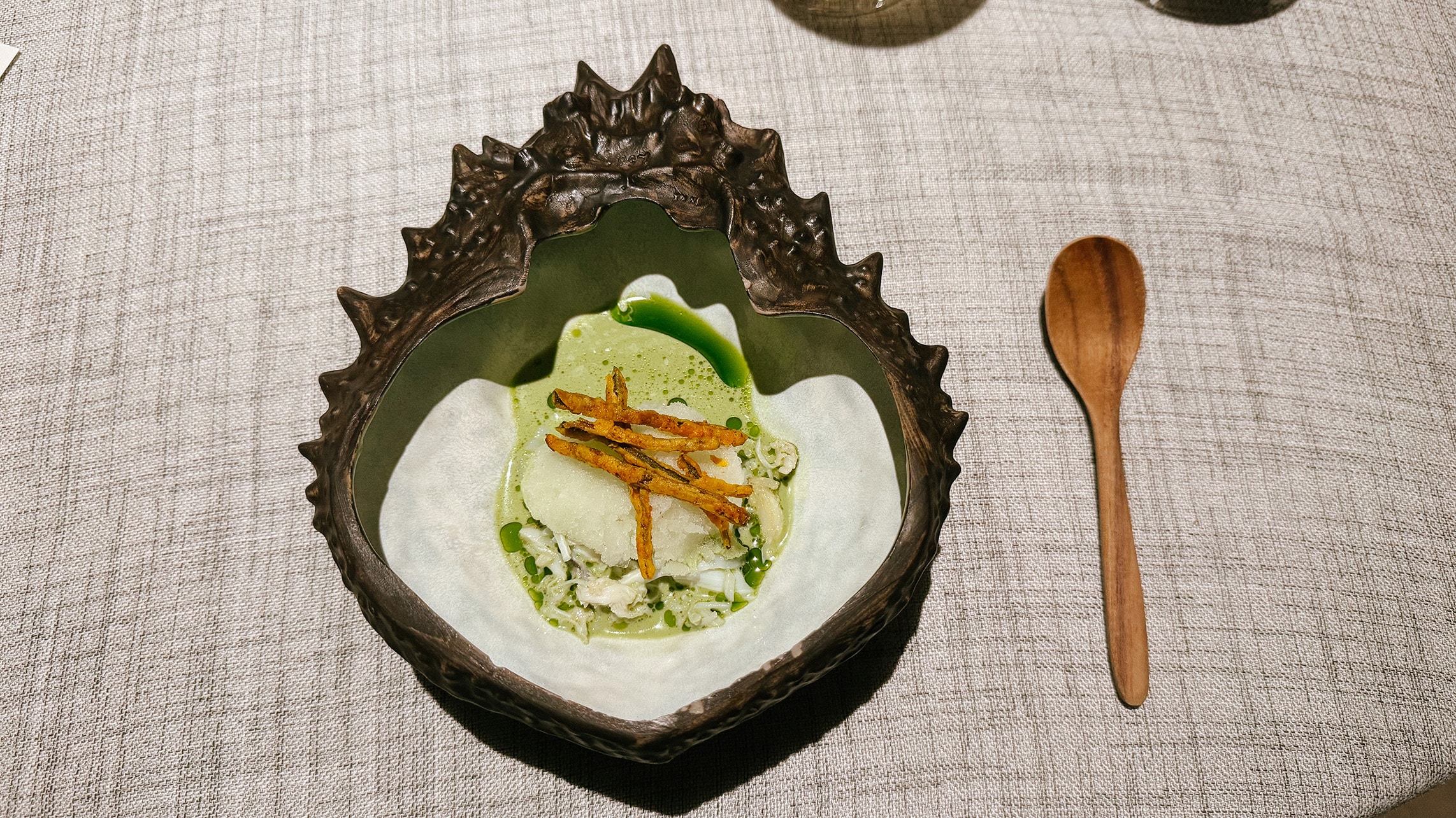 A course called Summer Curry presented in artistic ceramic tableware at Gaa Bangkok’s Michelin-star tasting menu.