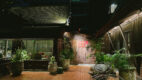 Night view of Gaa Bangkok’s courtyard with traditional wooden architecture and lush greenery.