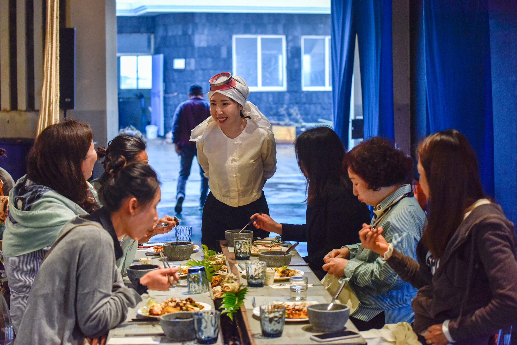 Immersive dining experience inspired by Jeju haenyeo culture with guests seated around a communal table
