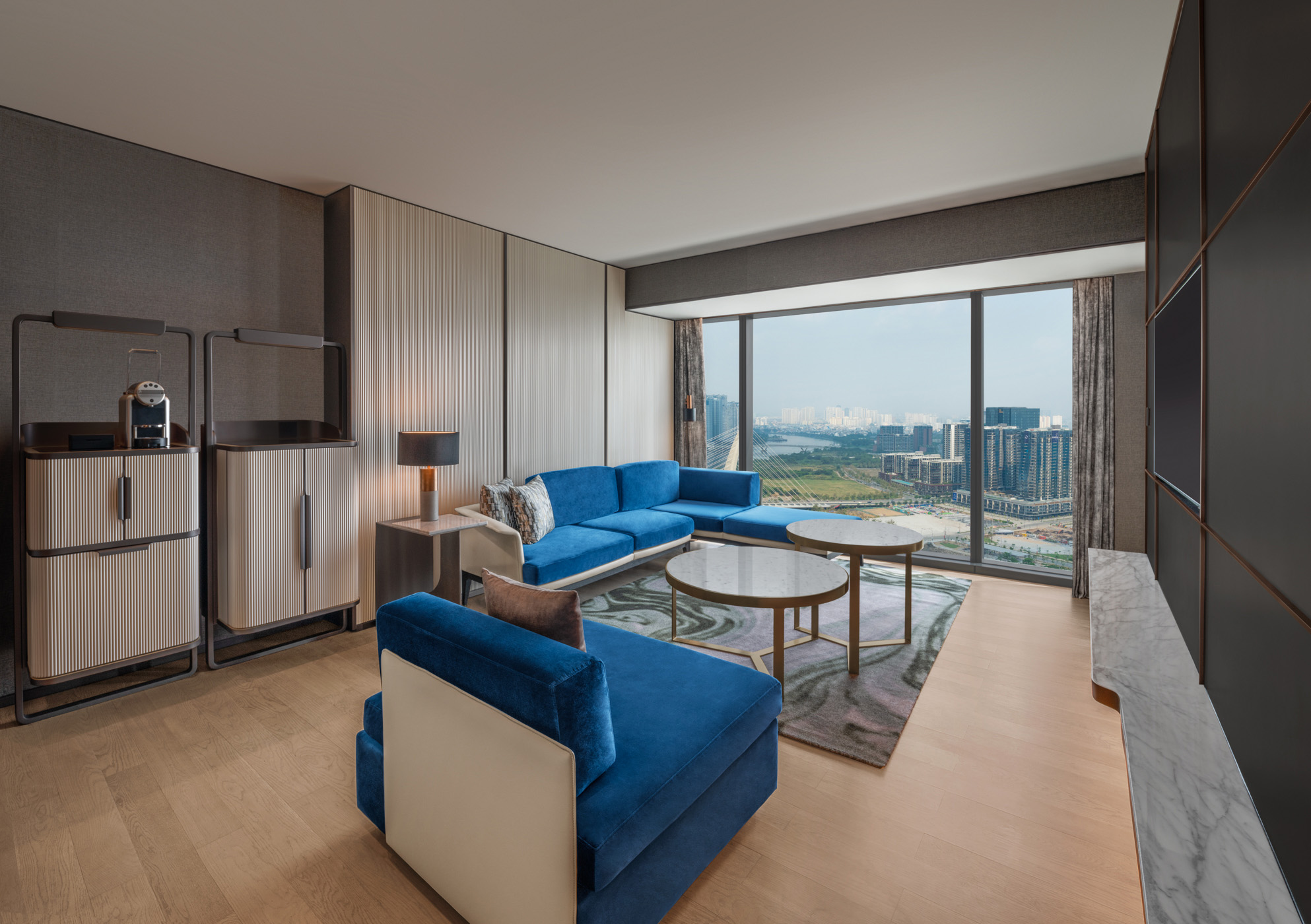 Spacious living room with blue sofa in King One Bedroom Suite at Hilton Saigon