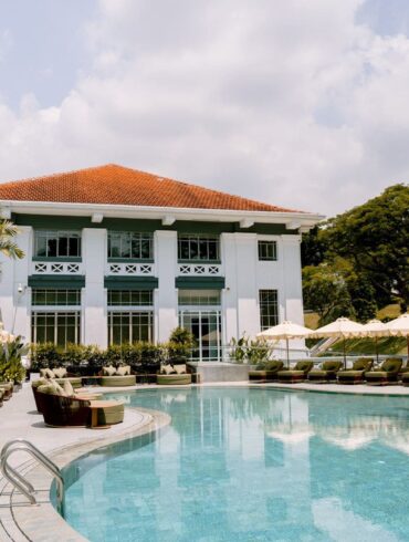 Madison House Singapore pool with heritage colonial building backdrop and poolside cabanas at Fort Canning