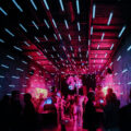 Crowd dancing under neon pink and blue lights inside an underground electronic music club in Moscow, Russia.