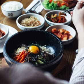 Korean bibimbap with egg yolk and assorted banchan on a dining table in Singapore