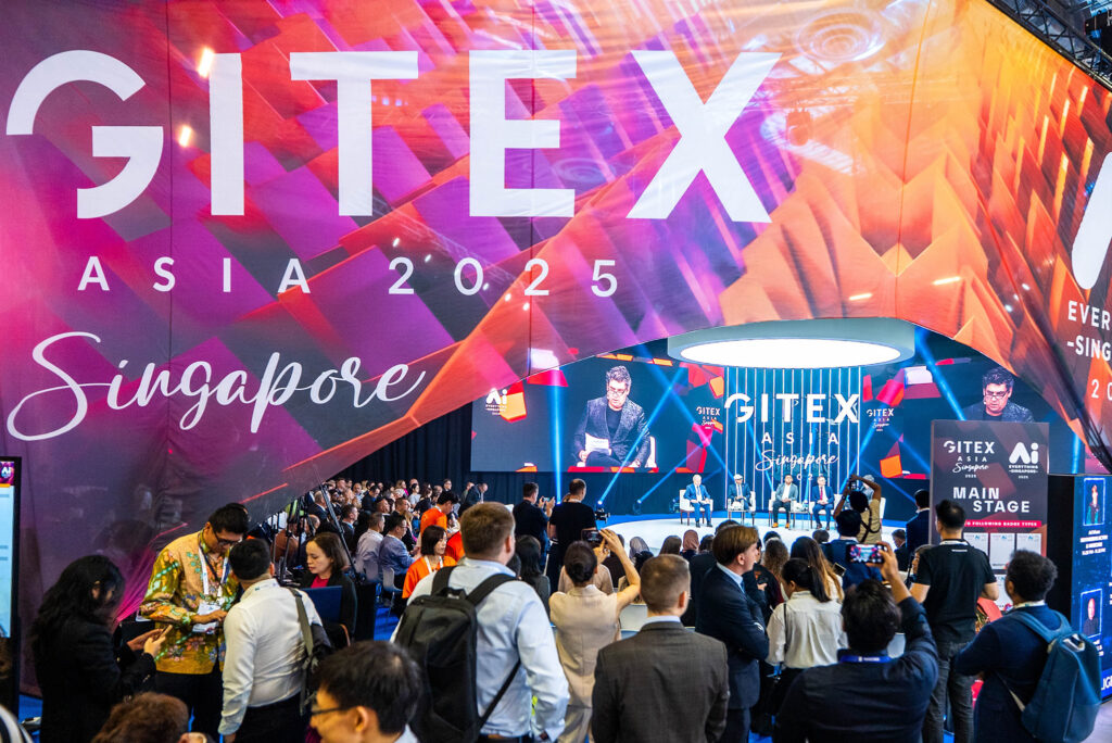 Crowd gathered at GITEX Asia Singapore conference with speakers on main stage and large digital backdrop