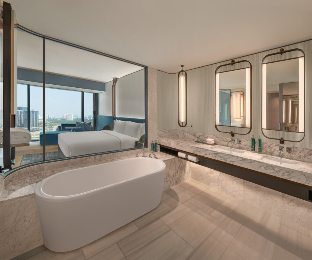 Marble bathroom with bathtub and double vanity in King One Bedroom Suite at Hilton Saigon