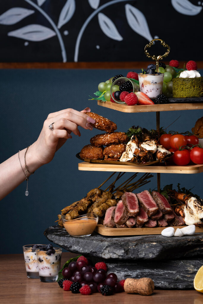 A three-tier Sunday brunch stack at Winestone, Mercure Singapore on Stevens, loaded with steak and eggs, gochujang wings, mornay baked prawns and matcha desserts.