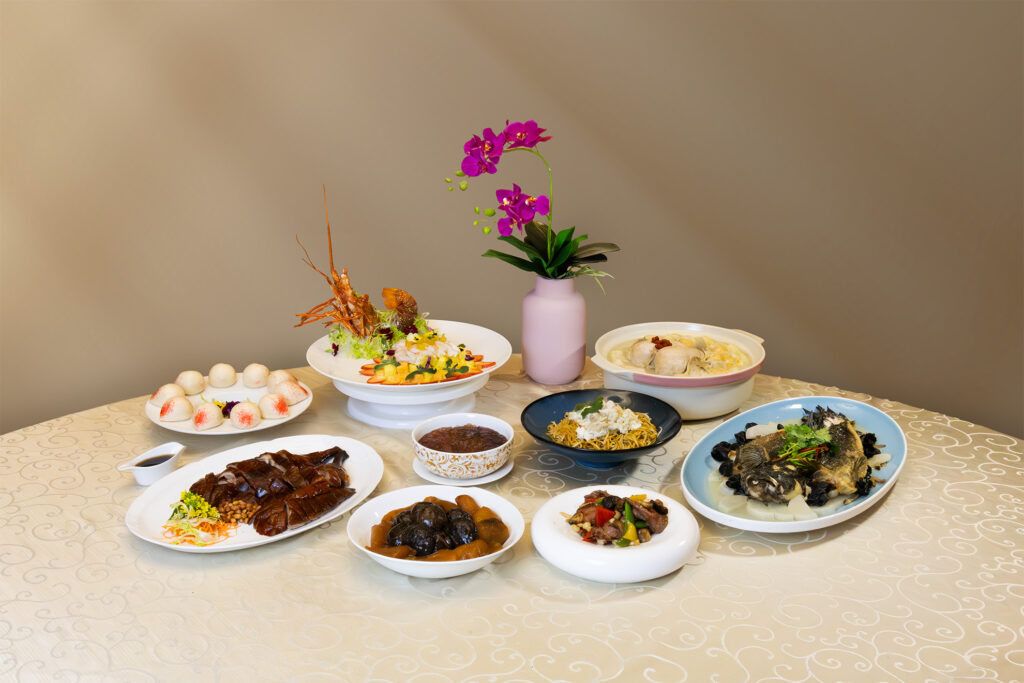A full spread of Xin Cuisine's Parents' Day set menu dishes including lobster salad, roasted duck, double-boiled soup, steamed fish, longevity noodles and longevity buns at Holiday Inn Singapore Atrium