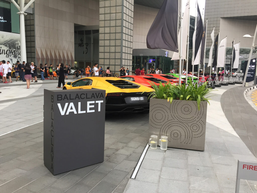 A row of colourful Lamborghinis lined up at a valet stand outside a Singapore venue