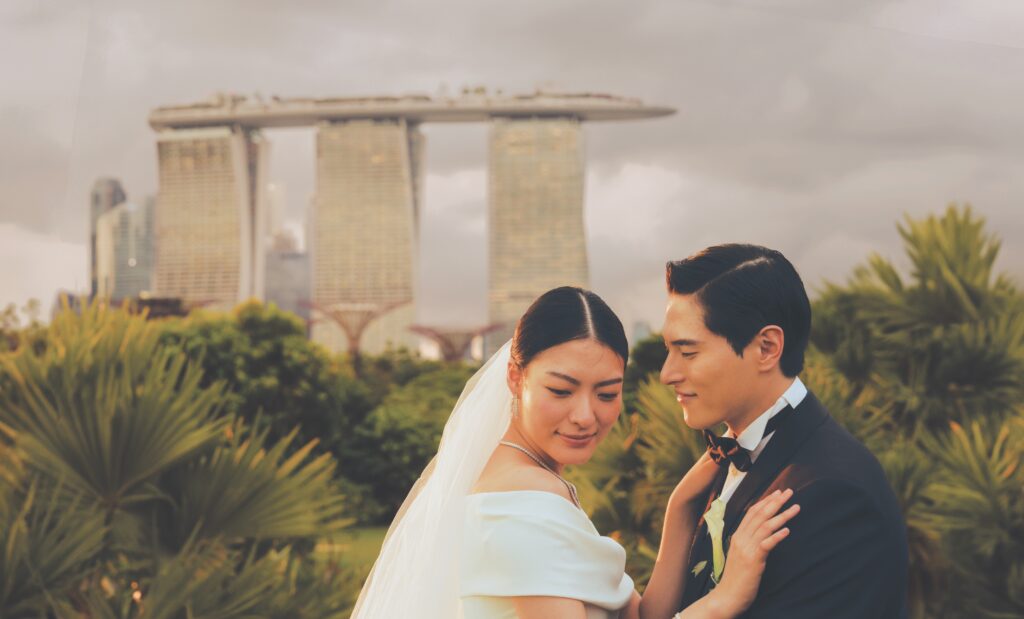 A couple in wedding attire with Marina Bay Sands and Gardens by the Bay in the background