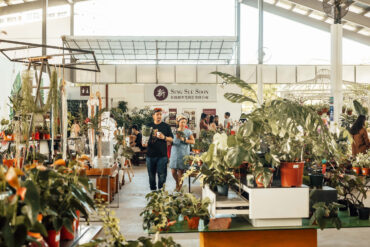 Visitors browsing plants and market vendors inside the Sing See Soon nursery at 5 Simei Lane, Singapore.