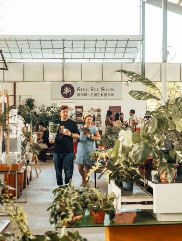 Visitors browsing plants and market vendors inside the Sing See Soon nursery at 5 Simei Lane, Singapore.