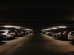 A dimly lit multi-storey carpark filled with cars at night