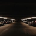 A dimly lit multi-storey carpark filled with cars at night