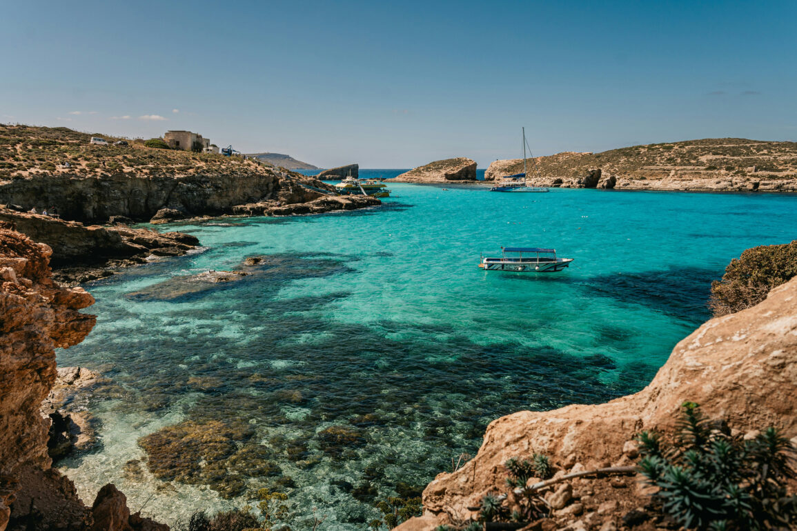 Blue Lagoon, Comino, Malta, with turquoise water, limestone cliffs, and boats anchored in a sheltered bay